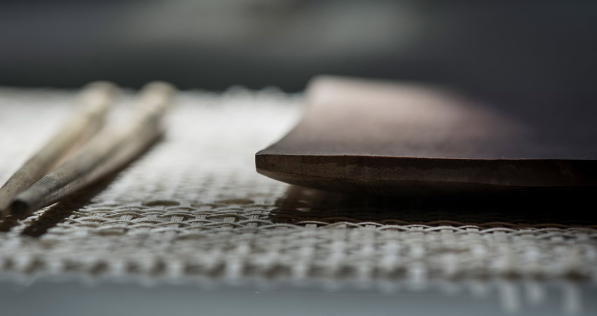 Plato de madera Sawoh sobre un individual de hilos de palma tejido a mano
