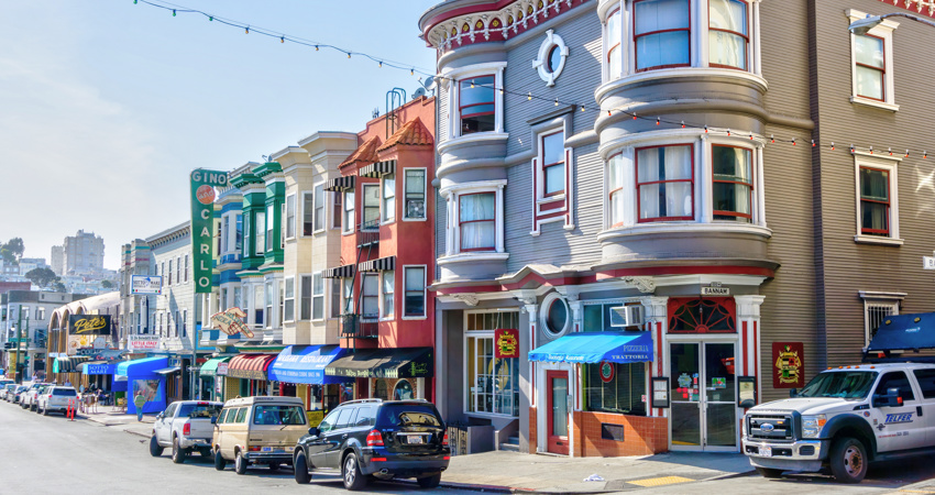 Colourful corner of Little Italy, with the awnings of the pizzerias at the bottom of the buildings.