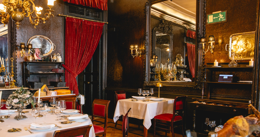 Lhardy: restaurante centenario. Por su salón (en la foto), decorado con lujoso terciopelo rojo y madera del siglo XVIII, han pasado reyes, políticos, intelectuales y celebrities.