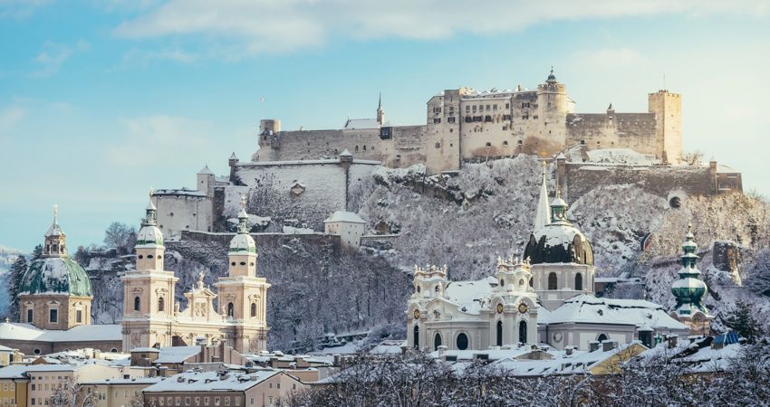 Viaja a Salzburgo por 22 500 Avios. En la imagen, vista de la Fortaleza de Hohensalzburg, sobre una colina, con los tejados nevados.