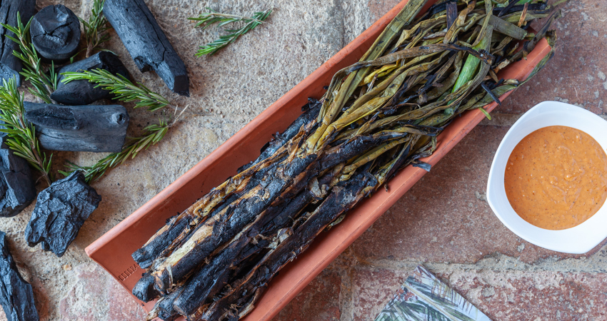 Calçotada típica en Can Travi, con los calçots servidos en una teja con salsa romescu