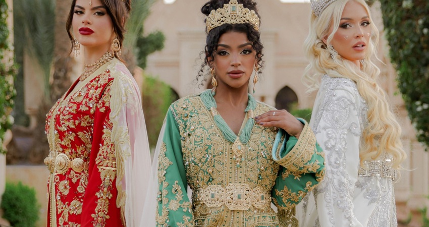 En la imagen, tres modelos posan con caftanes de lujo de la diseñadora Bouchra Filali Lahlou, en rojo y verde con bordados dorados, o en blanco con remates plareados.