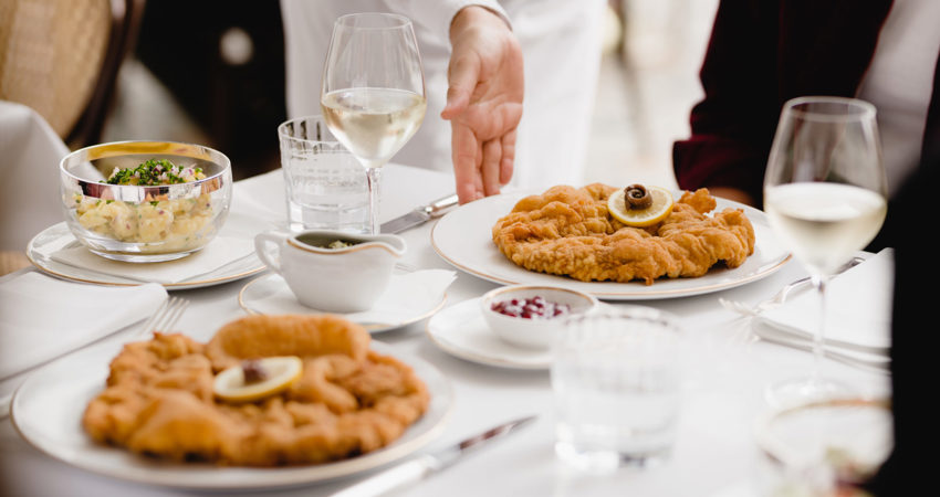 Dónde comer schnitzel en Viena. En la imagen, un camarero sirve un plato de schnitzel en Meissl & Schadn