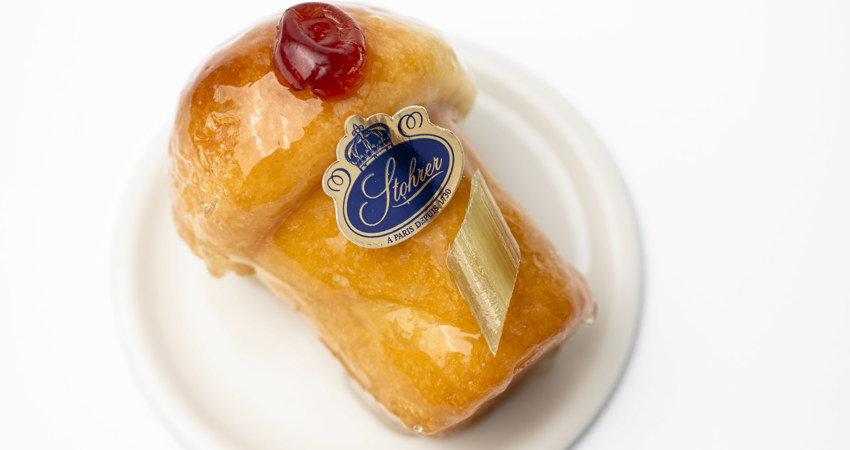 Las mejores pastelerías de París. En la imagen, un pequeño pastelito recubierto de caramelo transparente brillante, coronado con frutas confitadas y el escudo de Stohrer
