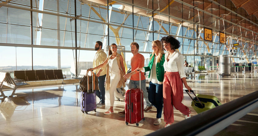 Un grupo de amigos pasea por la terminal 4 de Barajas con destino a uno de los vuelos de Iberia