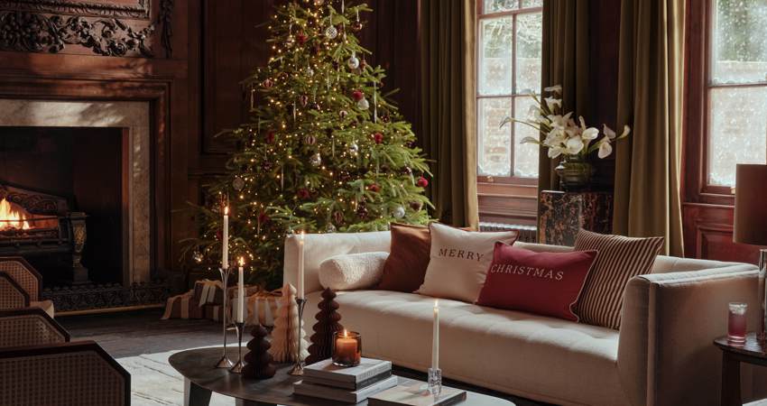 En la imagen, un salón con un árbol de Navidad y decoración de H&M Home