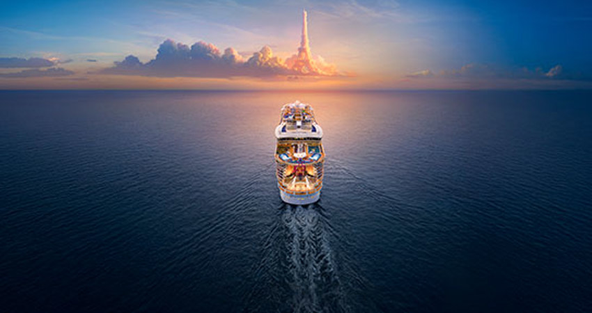 En la imagen puede verse la parte trasera de un crucero de Royal Caribbean, surcando el mar. En el horizonte, las nubes forman la Torre Eiffel