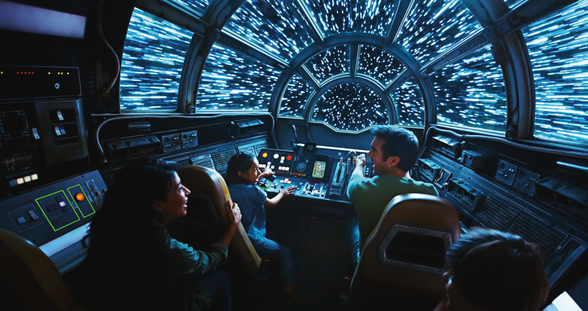 En la imagen, un adulto y dos niñas se sientan a los mandos de una nave espacial.